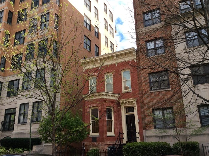 An illustration of Pressing Sha. The attached building on the side must be at least twice as tall as your building for Pressing Sha to exist. House between two tall buildings min - Avoid These 5 Types of Bad Feng Shui Outside Your Home